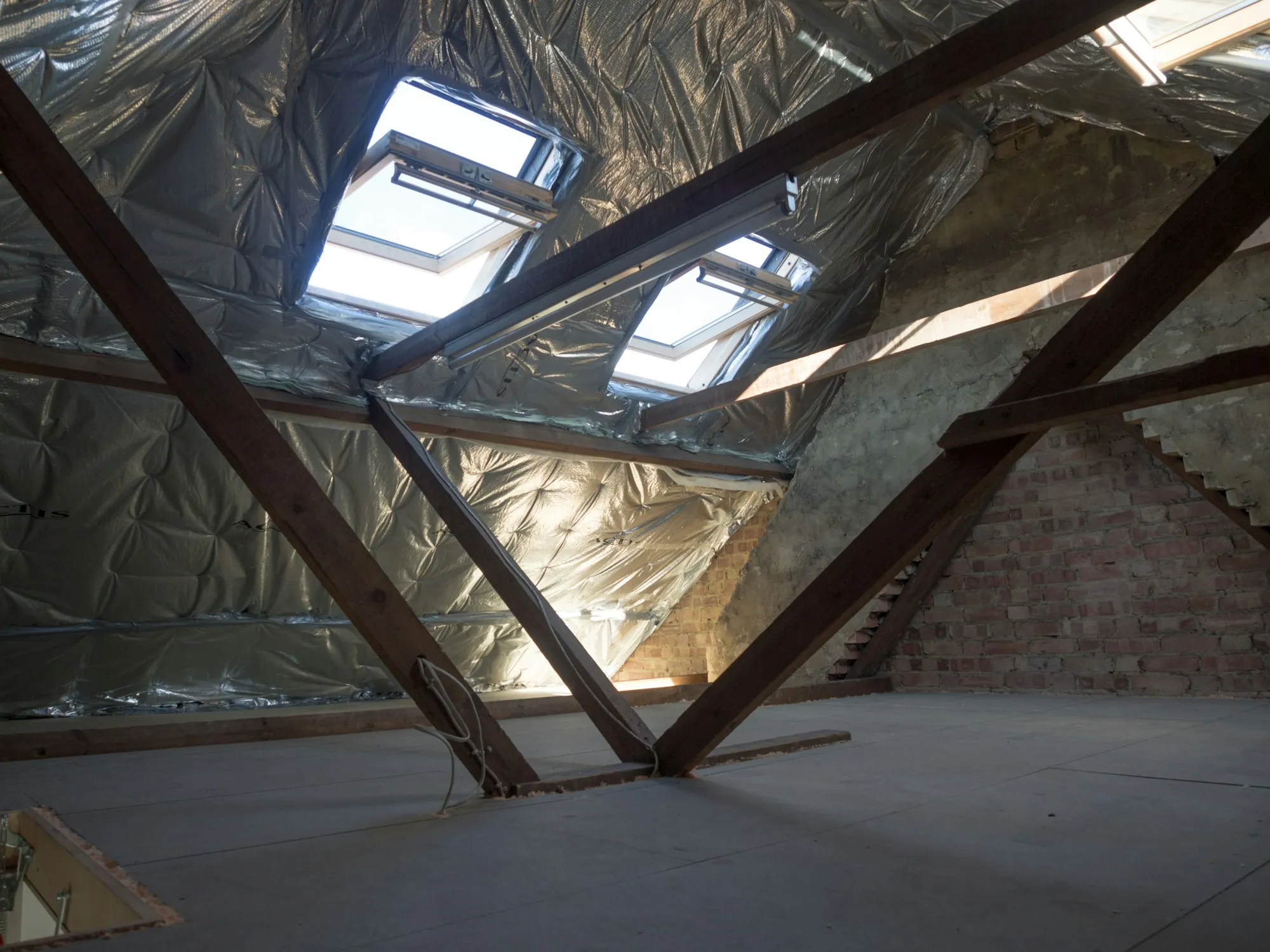 Insulated attic with foil-lined roof deck and skylights